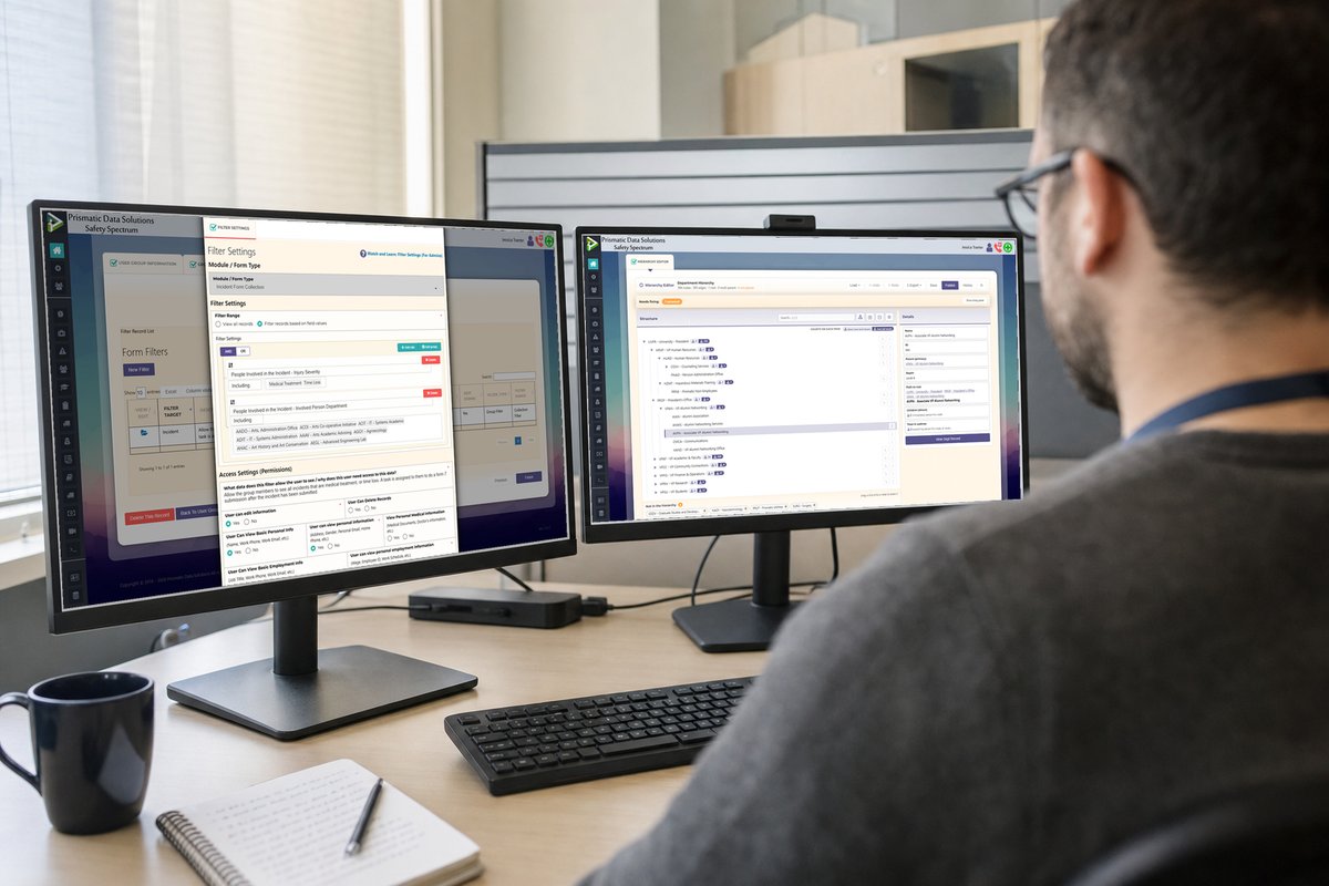 An IT administrator at two monitors configuring Safety Spectrum, a departmental org chart on the second screen.